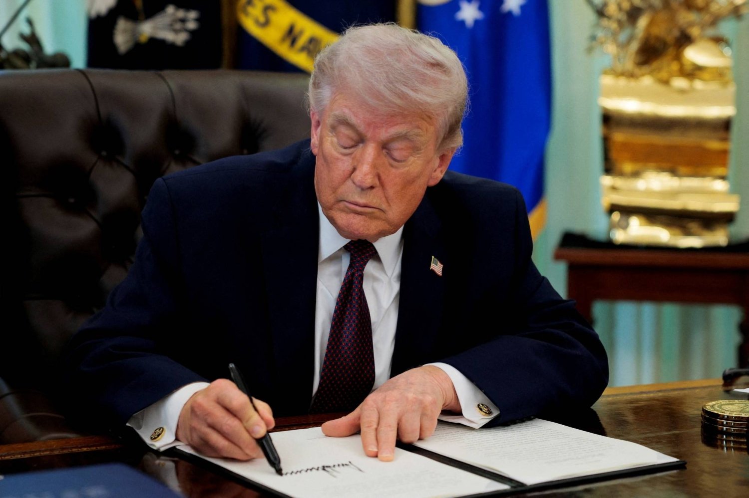 FILE PHOTO: U.S. President Trump signs an executive order in the Oval Office of the White House